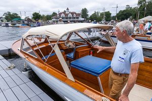 Visitor admiring a canopy-top classic boat