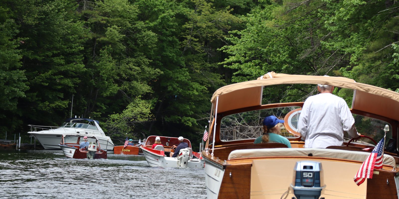 A classic boat cruising quietly up the Songo River