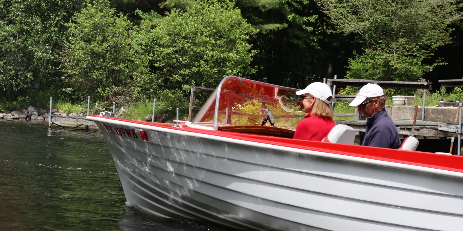 Karl and Laurie at the wheel of their mahogany runabout on a summer cruise